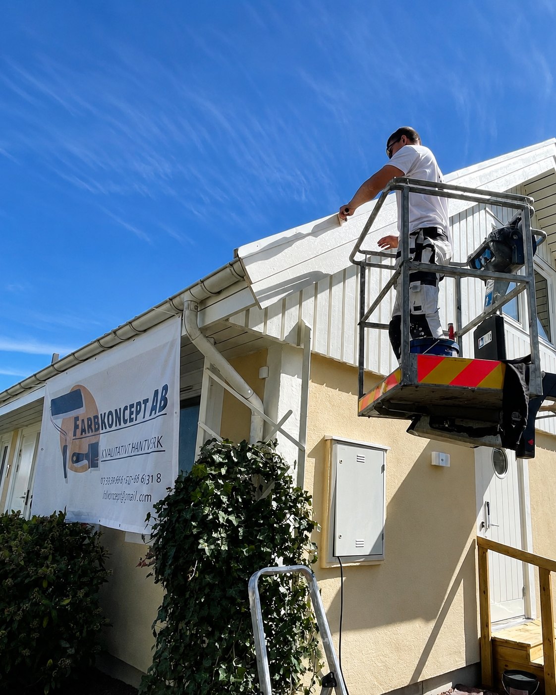 Målare i skylift som målar takfot på villa i Landskrona